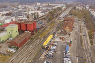 Industrial area with train station and train, surrounded by factories and buildings, shows urban