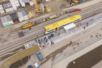Bird's eye view of a train station with a yellow train and working people, bus ride taken by the