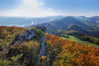 View from the Gisliflue of an autumn-colored forest, behind the Jurassic foothills with water fluh