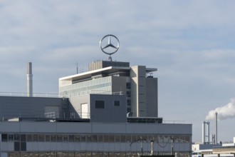Mercedes-Benz logo on a large industrial complex under cloudy sky, Mercedesstern,