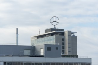 Modern factory building with Mercedes logo under cloudy sky, Mercedes Star,