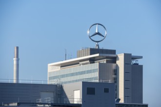 Industrial building with Mercedes logo and chimney, modern building style under blue sky, Mercedes