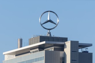Close-up of a roof with emblazoned Mercedes logo and chimney surrounded by blue sky, Mercedes star,