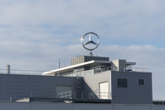 Large industrial complex with Mercedes-Benz logo under cloudy sky, Mercedes Star,