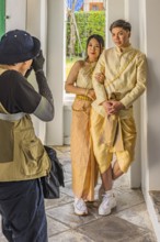 Young woman and young man in traditional clothing present themselves for the photographers, Wat