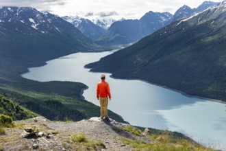 Mountaineer enjoys views of blue lake and mountains on Twin Peaks Trail, Eklutna Lake, Chugach