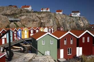 Colourful boathouses in a rocky coastal landscape under blue sky, Smögen, Västra Götaland, Sweden