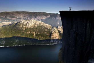 Impressive view of Prekestolen with a person on the edge of the cliffs