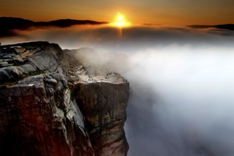 Sunrise over a sea of clouds illuminates the cliffs of Preikestolen, Preikestolen, Rogaland, Norway