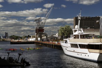 Old port of Tjuvholmen with ships and cranes against a cloudy backdrop, Oslo, Norway