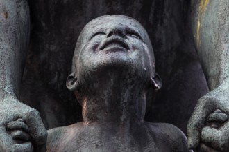 Detail of a bronze sculpture in Vigelandsparken shows a child's face with expressive facial