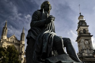 Robert Burns statue in front of historic backdrop with Gothic church tower in Dunedin, Dunedin,