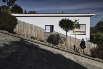 Steep road with a white building, trees and shade in Dunedin, Dunedin, Otago, New Zealand