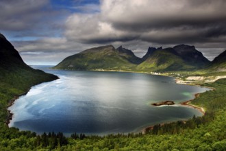 View of the picturesque coastline of Bergsbotn with majestic mountains and calm water, Senja,