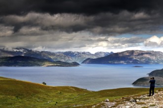View of Lyngen Fjord with dramatic clouds and hikers, Lyngen Fjord, Troms, Norway