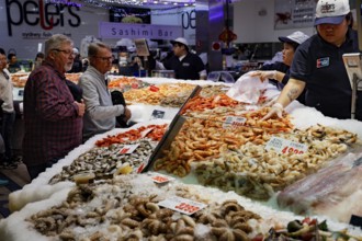 Customers look at the diverse selection of seafood at a busy sales stand, Sydney, Australia