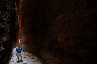 Hikers in the dark, impressive Echidna Chasm with narrow rock walls, Purnululu, Western Australia,