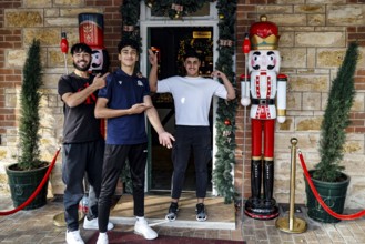 Three people standing smiling in front of a gift shop in Hahndorf, Hahndorf, South Australia,