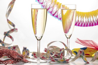 Two champagne glasses filled with colorful streamers, carnival