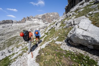Two mountaineers on a hiking trail to Sella della Tosa, mountainous landscape in the Brenta
