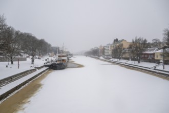 Ships moored on the banks of the frozen Aurajoki River, wintery Turku or Swedish Åbo,