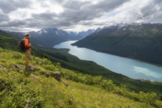 Mountaineer enjoys views of blue lake and mountains on Twin Peaks Trail, Eklutna Lake, Chugach