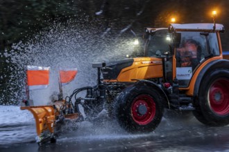 Winter service, spreader and snow plough in use, clears snow and slush from a regional road,