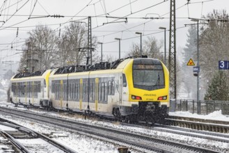 Regional train from Arverio on its way through a winter landscape in snowfall. The railcar train is