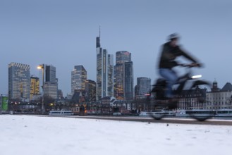 The towers of the Frankfurt banking skyline rise behind the snow-covered banks of the Main,