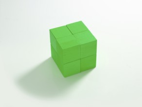 8 green wooden cubes against a white background