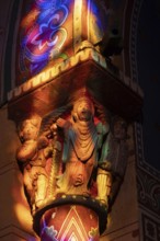 Issoire. Pillar (The Annunciation made to Mary) . The figures are illuminated by colorful light