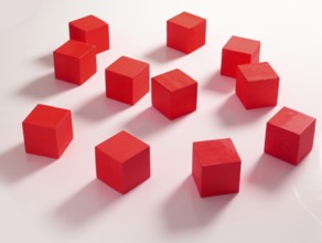 11 red wooden cubes against a white background