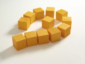 12 yellow wooden cubes against a white background
