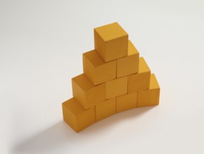 10 yellow wooden cubes against a white background