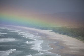 Tallow Beach bay with rainbow, lookout Byron Bay lighthouse, New South Wales, Australia