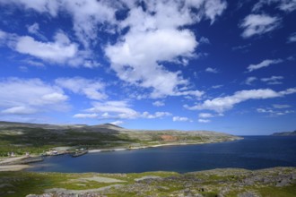 Green meadows on the banks of Syltefjord with clouds in the blue sky, landscape with a lake and