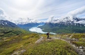Climbers on a hiking trail, Slaughter Ridge Trail, view of snowy mountains and turquoise lake Kenai