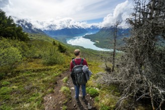 Climbers on a hiking trail, Slaughter Ridge Trail, view of snowy mountains and turquoise lake Kenai