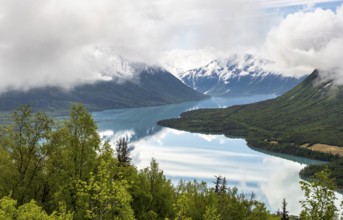 View of snowy mountains in spring and turquoise Kenai Lake with reflection, Slaughter Ridge Trail,
