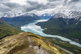 Climbers on a hiking trail on Slaughter Ridge, views of snowy mountains in spring and turquoise