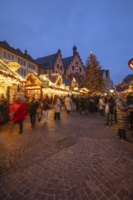 December 22, 2025, Frankfurt Christmas Market on Roemerberg at twilight. Traditional wooden stalls