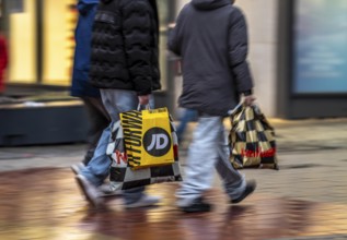 Pedestrian zone, passers-by hurrying, shopping between the years, exchanging, shopping bags,