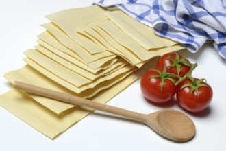 Lasagna, dried lasagna leaves with tomatoes and cooking spoon