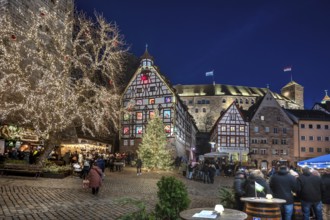 Christmassy illuminated square with the historic Pilate House with advent calendar, in the evening