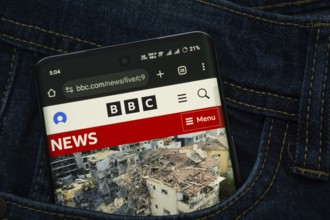 Dhaka, Bangladesh- 15 June 2025: A smartphone displaying the BBC web interface peeks out of a denim