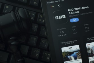 Dhaka, Bangladesh- 28 Oct 2025: An iPad displaying the BBC app against a judge's gavel and dark