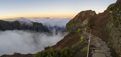 Sunrise at Pico do Arieiro, clouds of fog sweep over mountain peaks, sea of fog, hiking trail PR1,