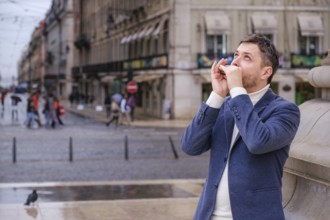 Man musician in a blue blazer and white sweater playing blues on a harmonica with eyes closed,