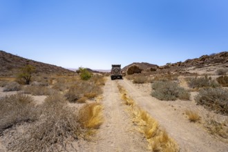 Toyota Hilux off-road vehicle on a sandy track, desert landscape with Brandberg, Erongo,