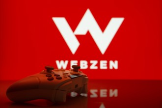 Dhaka, Bangladesh- 14 Nov 2025: A close-up of a white gamepad with the Webzen seen on screen in the